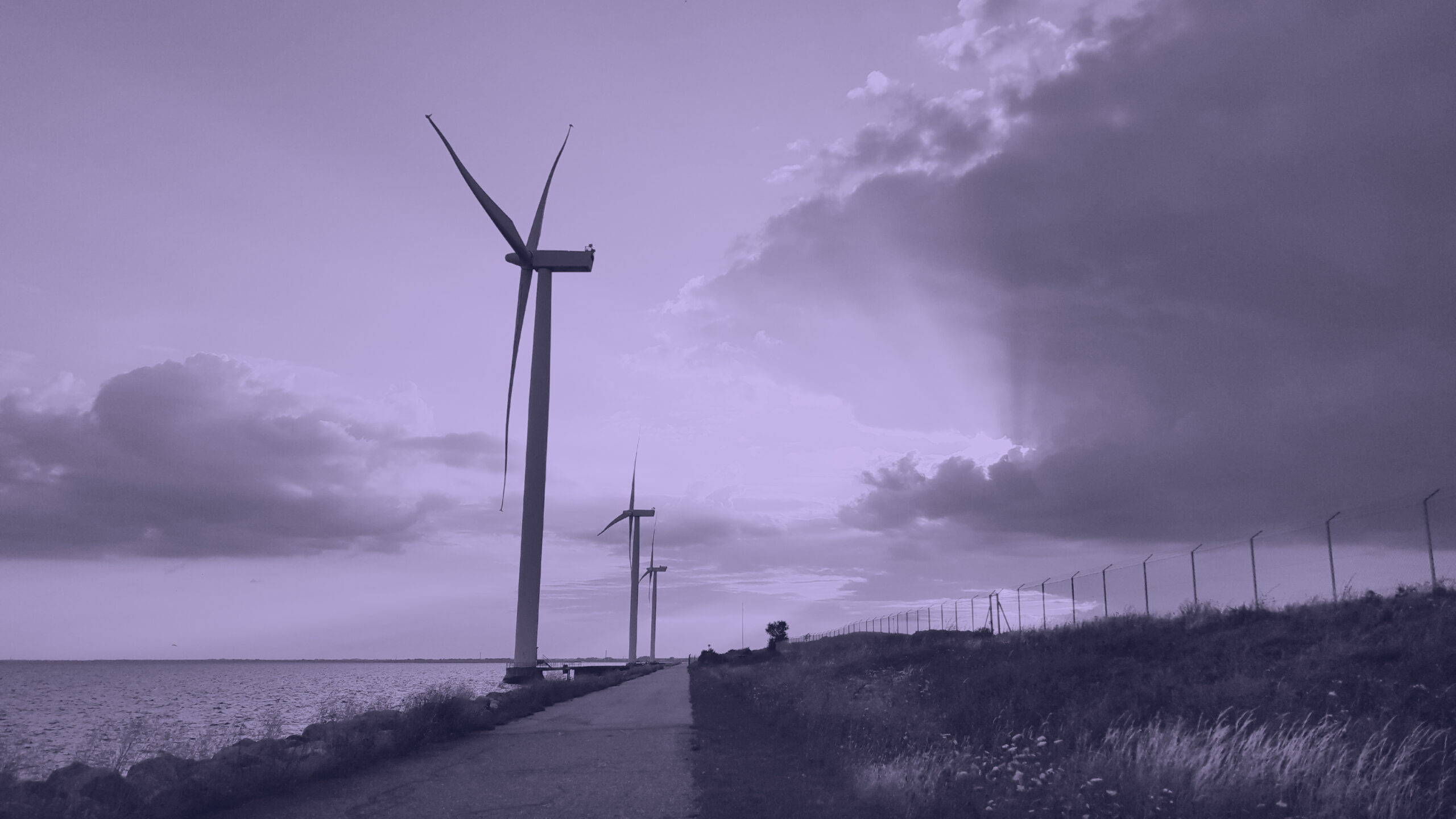 Wind turbines located right on the Danish coast, at sunset.